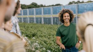 Ph.d.-studerende Kamau Lindhardt ved Aarhus Universitets forskningscenter i Foulum, AU Viborg, foran bifaciale solpaneler. Foto: Jens Hartmann Schmidt, Aarhus Universitet